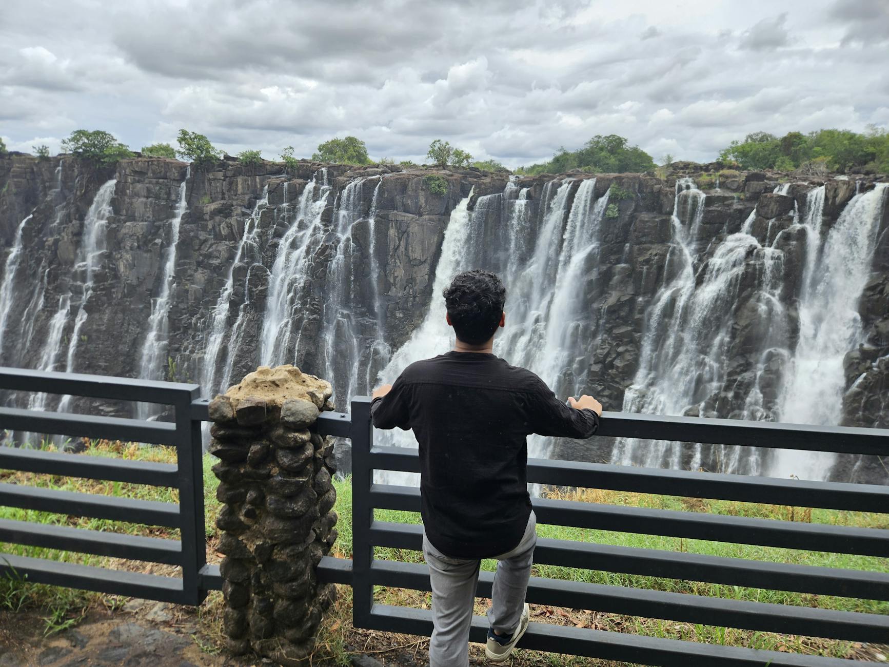 Mężczyzna podziwia potężny wodospad w słoneczny dzień