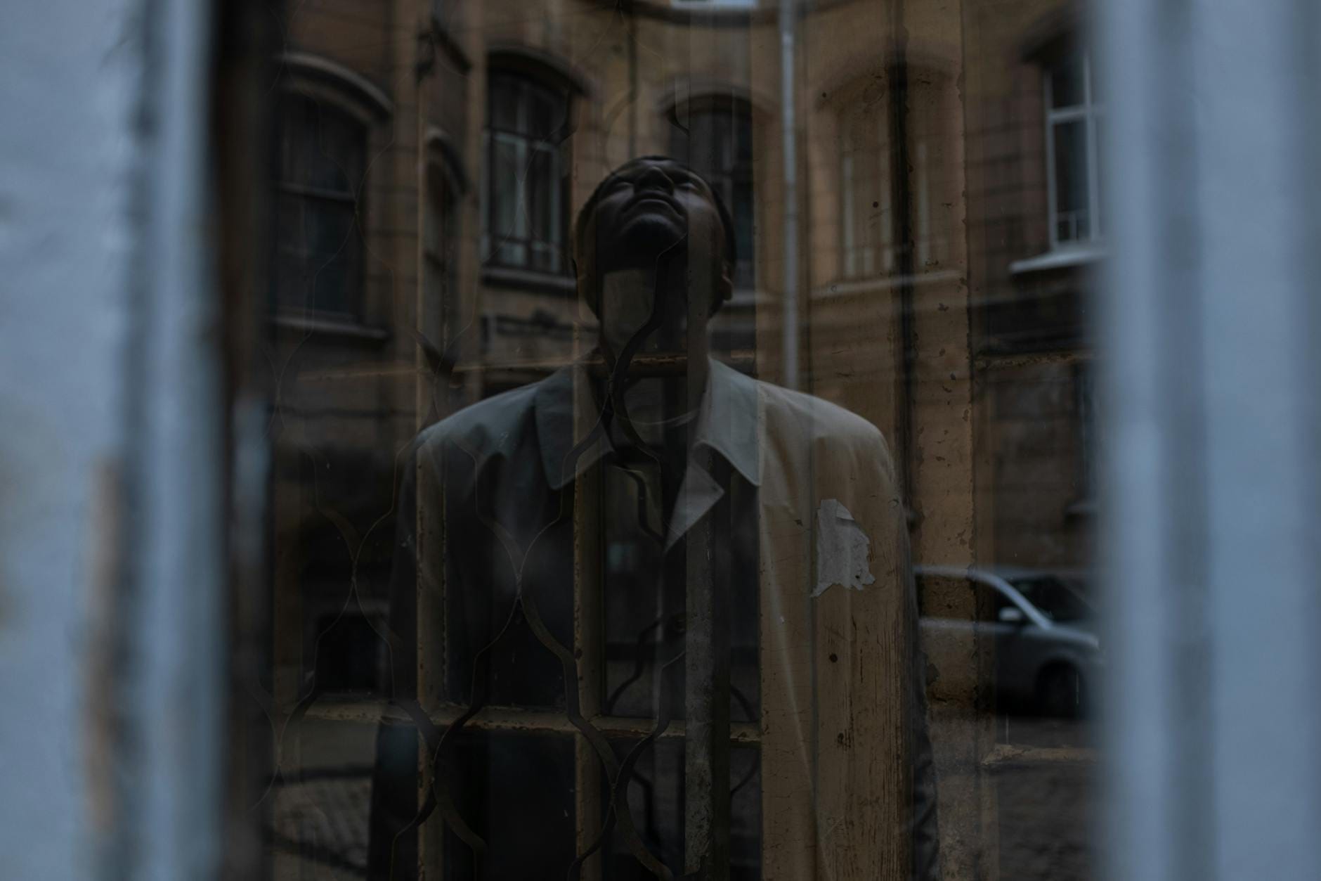 Legenda o studni w Lublinie: dlaczego nikt nie chciał do niej zaglądać? Zamyślony mężczyzna w starym oknie kamienicy na lubelskim dziedzińcu