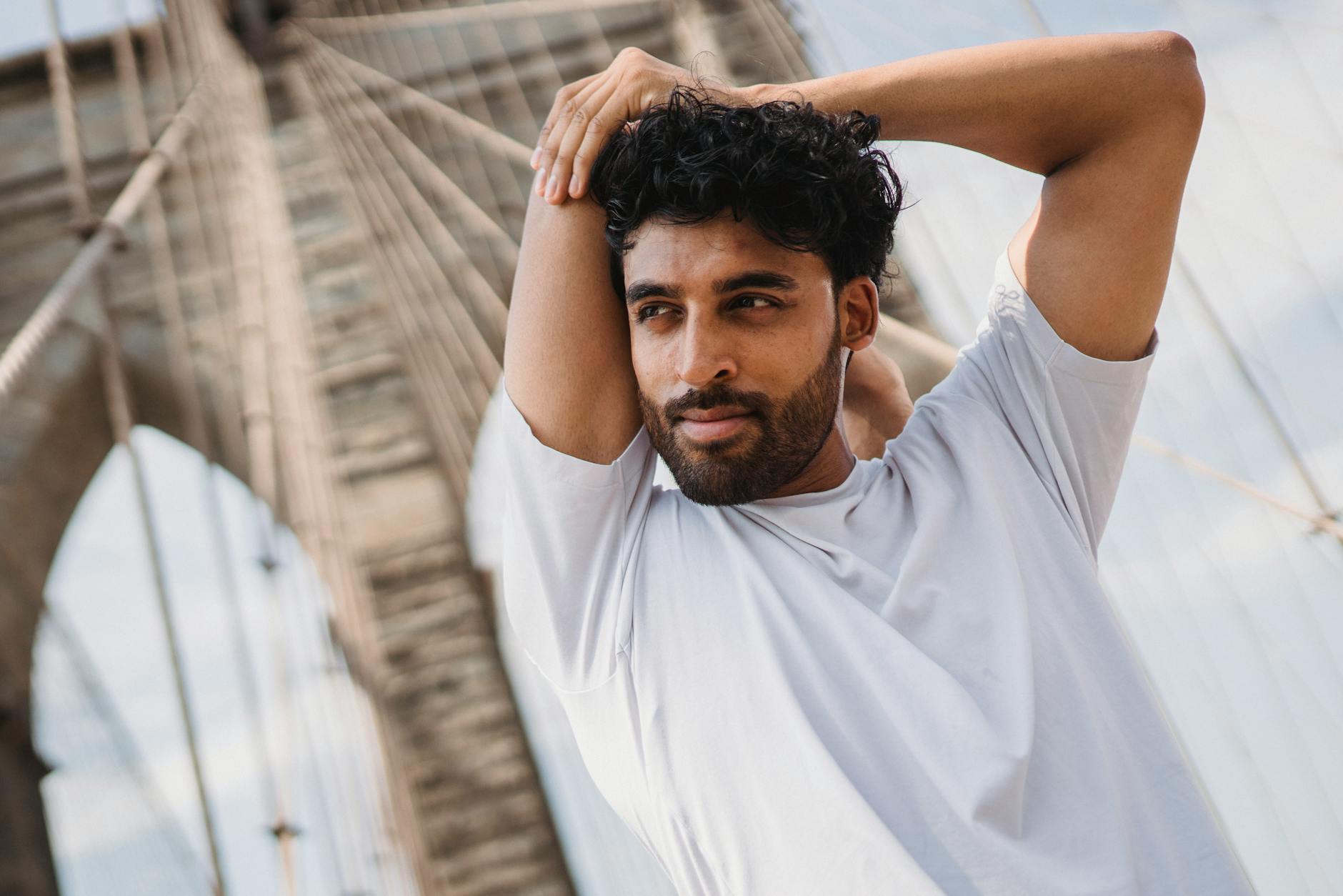 Mężczyzna rozciąga się na moście w mieście podczas aktywnego zwiedzania