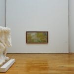 Osoba ogląda rzeźby i obrazy w nowoczesnej galerii sztuki w Lublinie