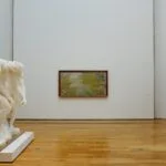 Osoba ogląda rzeźby i obrazy w nowoczesnej galerii sztuki w Lublinie