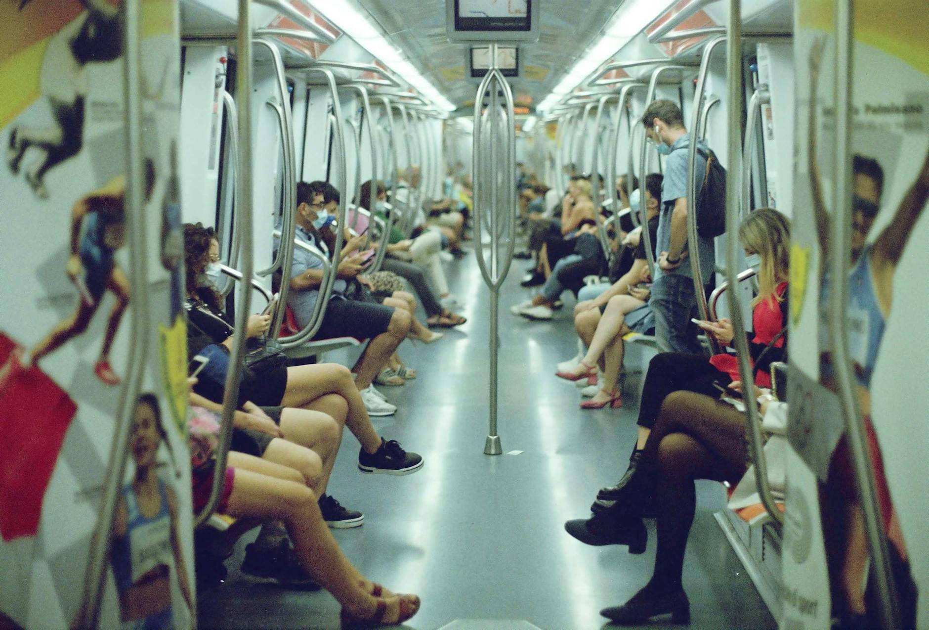 Pasażerowie w wagonie metra siedzący naprzeciwko siebie