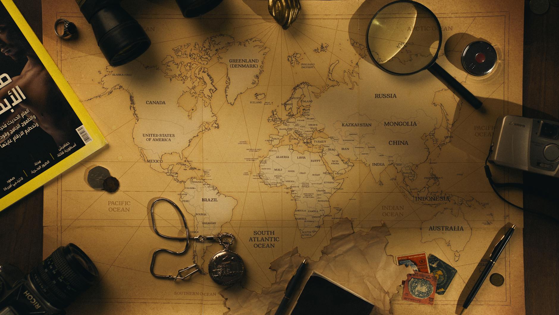 Przybory poszukiwacza skarbów rozłożone na starej mapie świata
