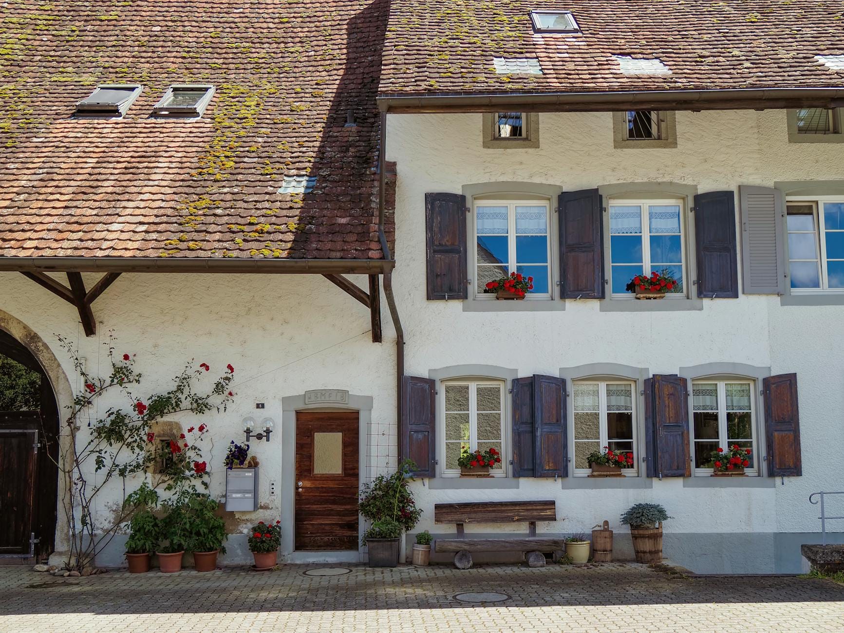 Rustykalny pensjonat z drewnianymi okiennicami i kwiatami na balkonie