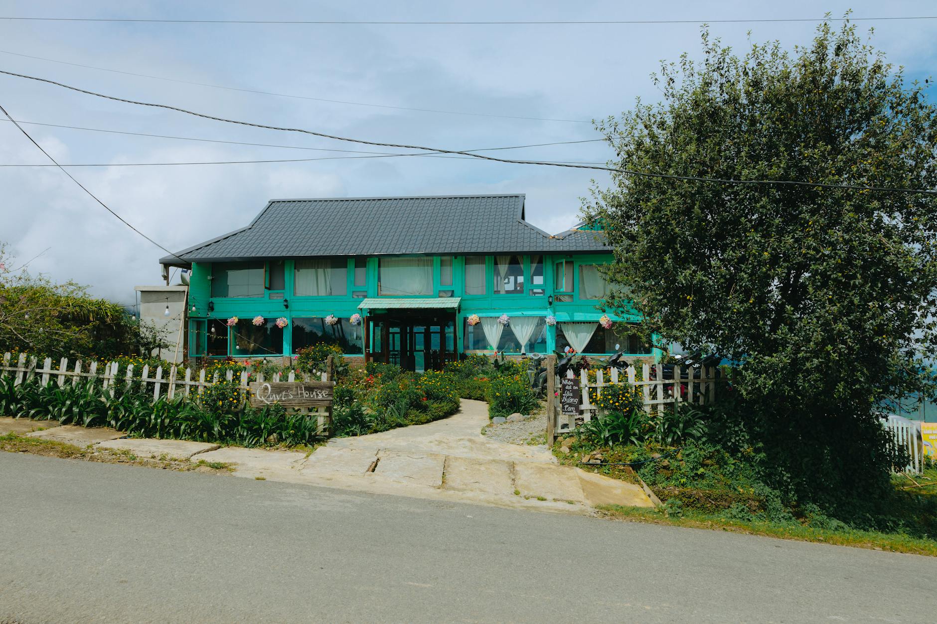 Zielony dom gościnny przy spokojnej drodze w otoczeniu bujnej zieleni