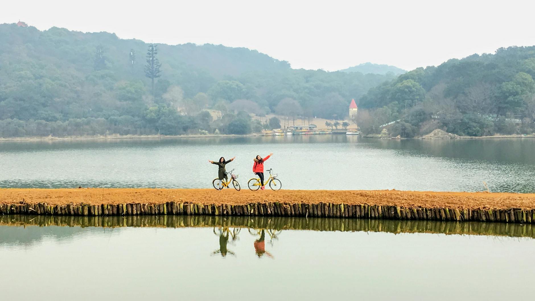 Dwóch rowerzystów odpoczywa nad jeziorem w mglisty dzień