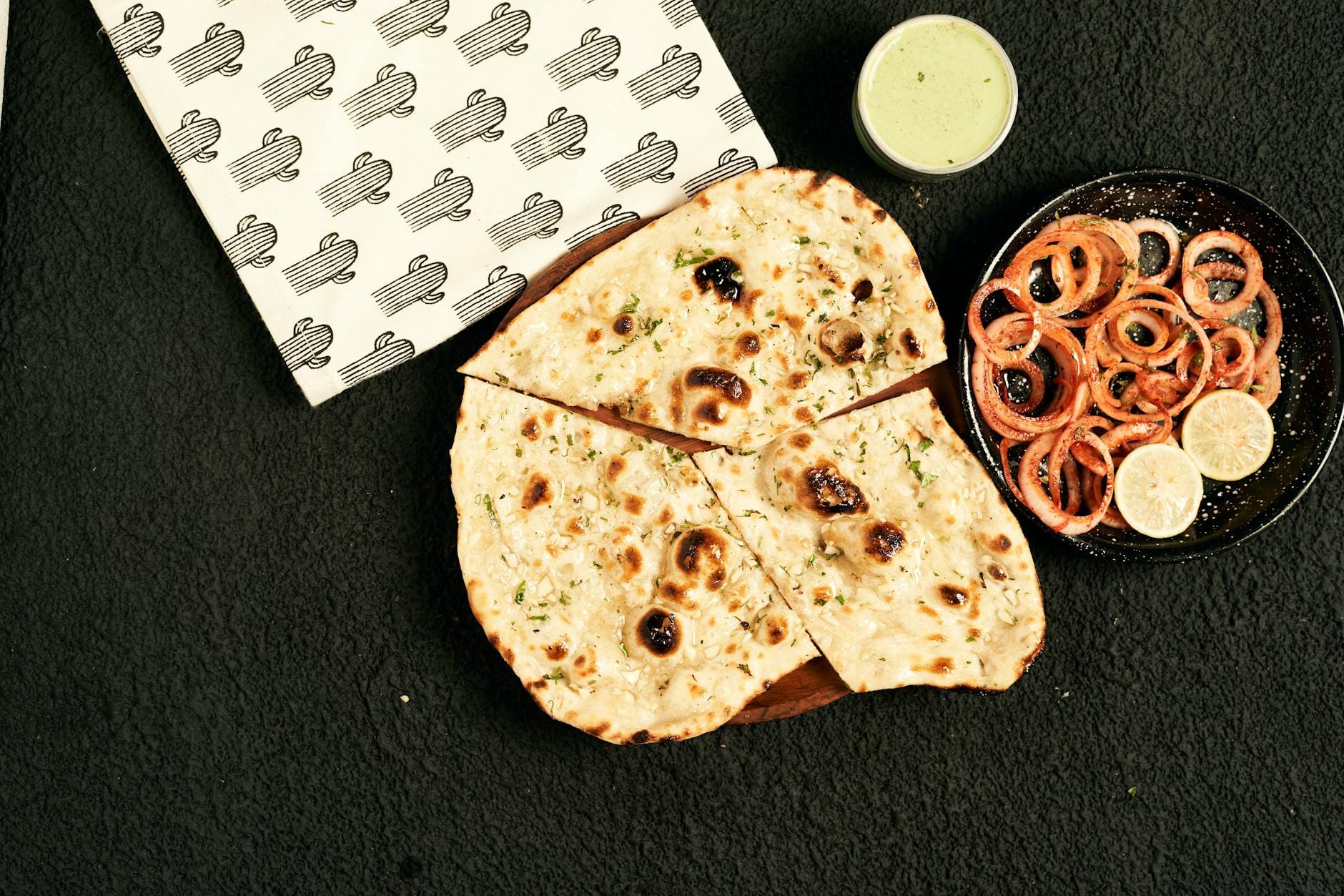Indyjskie naan z sałatką z cebuli i zielonym chutney na talerzu